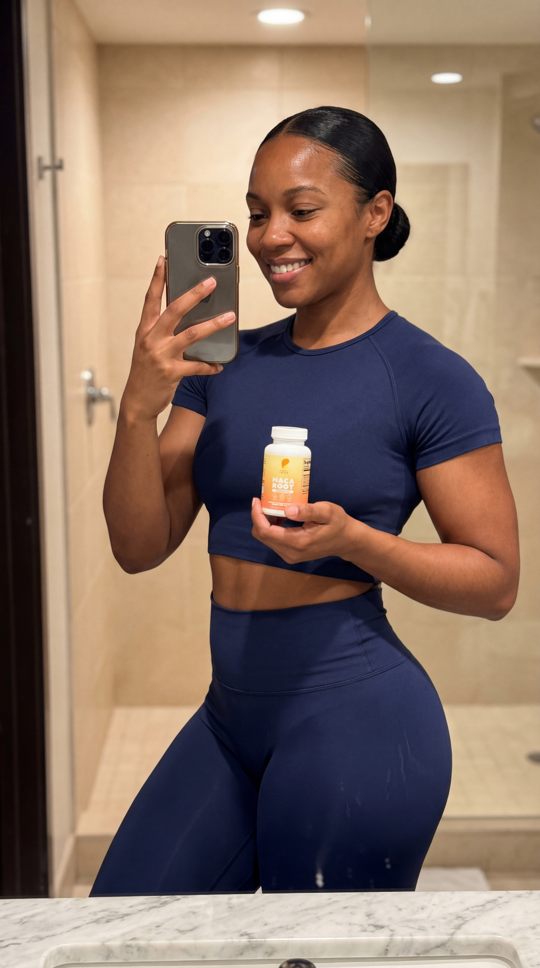 Woman in fitness attire holding Maca Root supplement